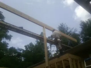 Carpenter setting a ridge beam over a new addition frame — Ice Dam Removal by Roofing Brothers in Morse