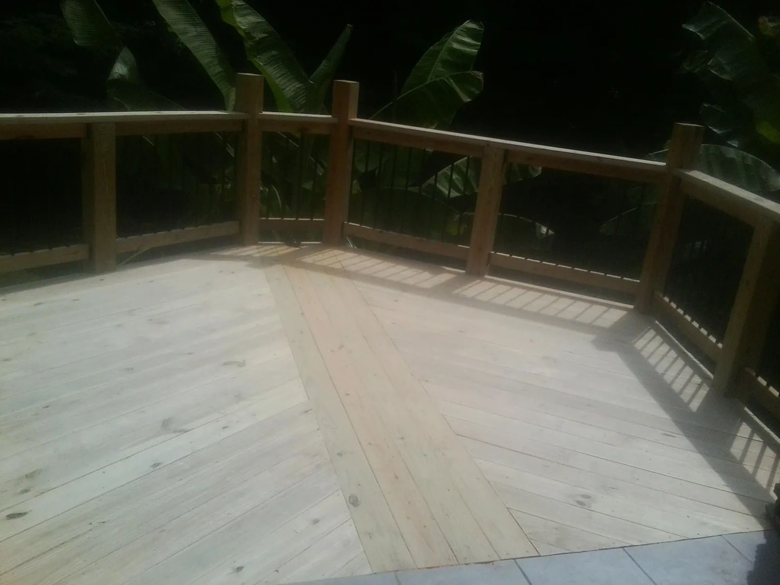New wood deck and railing built off the back of a home in Morse