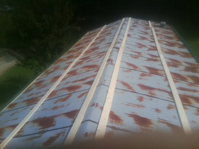 Rusted metal roof panels with new wood purlins before replacement — Storm Damage Roof Repair in Morse by Roofing Brothers