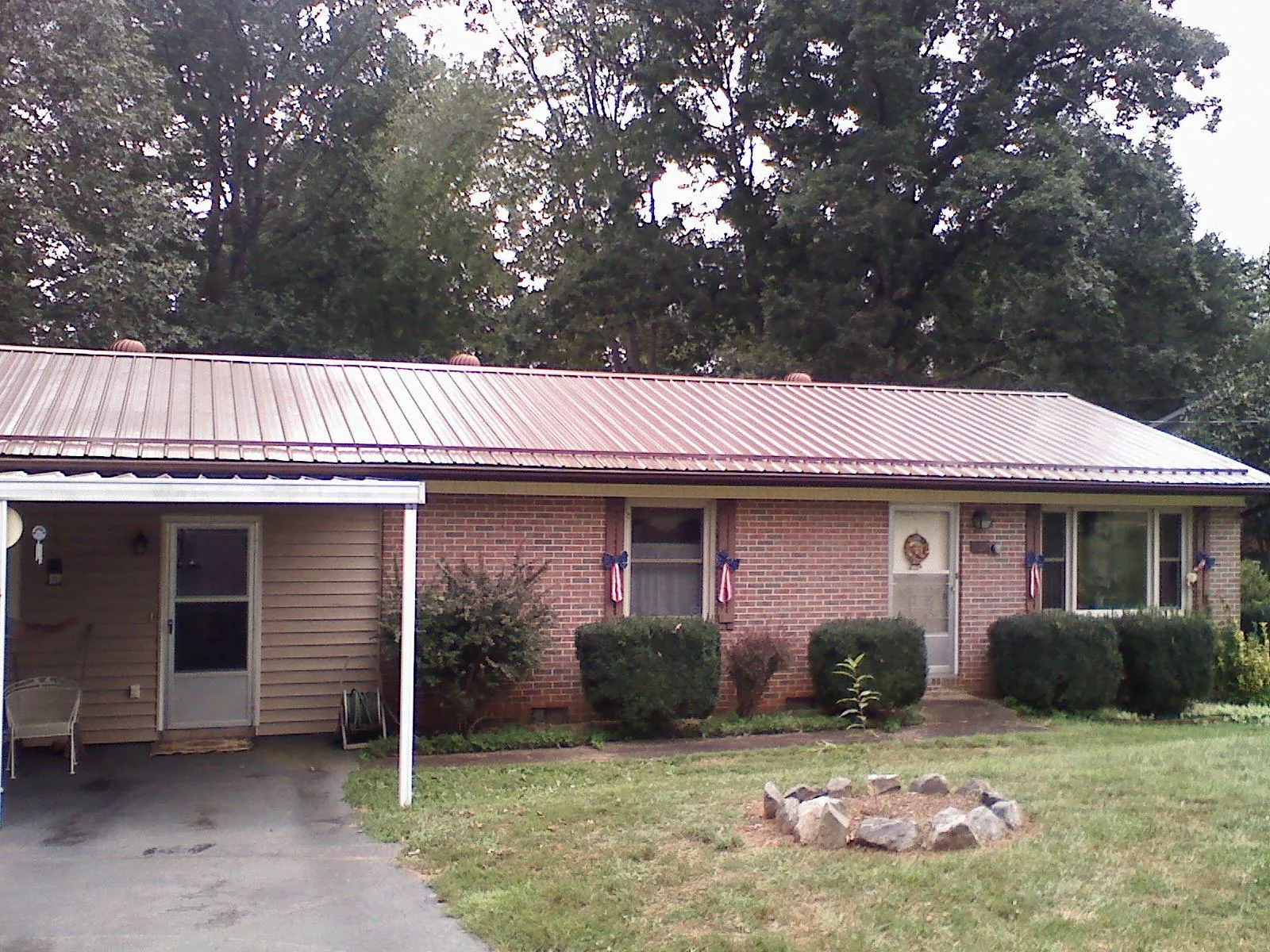 Bronze metal roof and carport on a brick ranch home — Roof Repair work by our crew in Morse