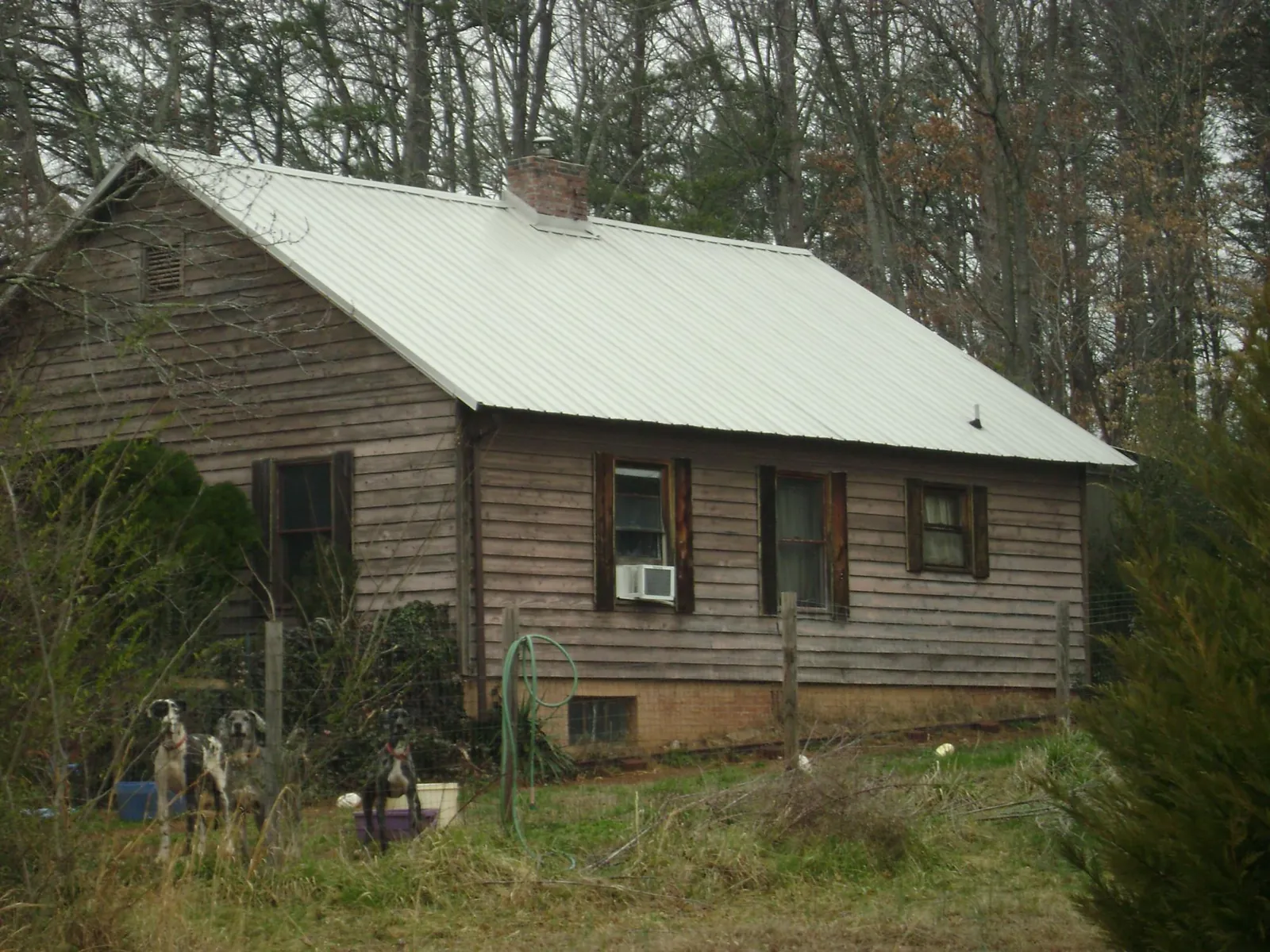 White metal roof on an old wood sided farmhouse, from a Metal Roof Installation job in Morse
